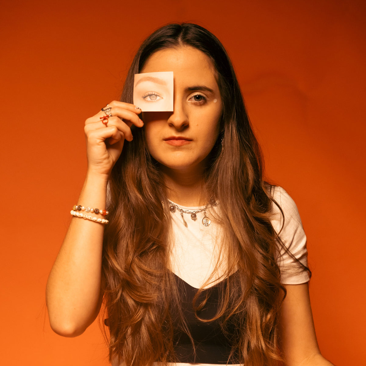 Artist holding an magazine cut out replacing her eye for the one in the cut out