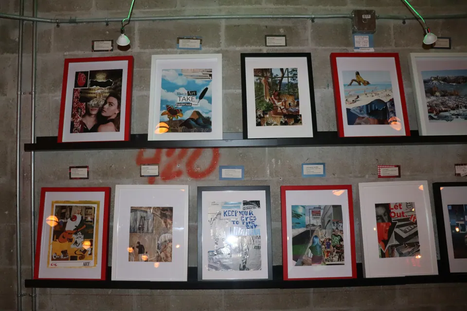 Two ledges of collages in red, white and black frames on a grey block wall.